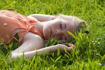 十几岁的女孩躺在高高的草丛中