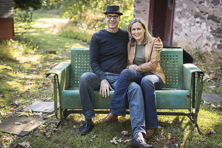 成年夫妇的肖像坐在户外的长凳上