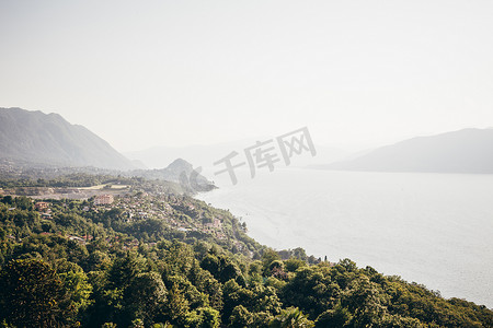 意大利伦巴第卢伊诺雾蒙蒙的树木覆盖的山脉环绕着湖