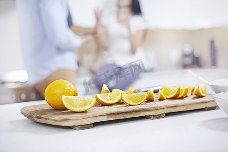 厨房柜台上摆在年轻夫妇面前的四分橙子