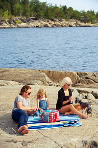 一家人在湖边的岩石上野餐