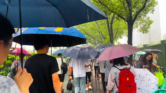 夏季暴雨摄影照片_实拍夏季暴雨天气行人打伞