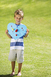 爱情标题摄影照片_抱着蓝纸心的小男孩
