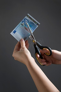 女性手在切割欧元纸币