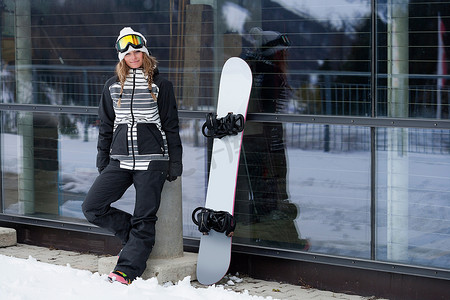 街机摄影照片_滑雪板运动员站在小屋旁