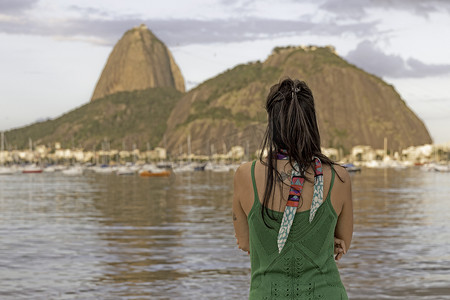 中年妇女望向巴西里约热内卢博塔福戈湾的甜面包山