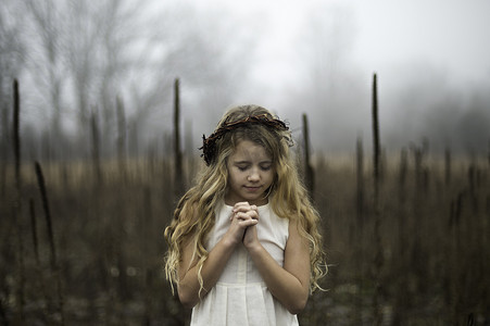 雾蒙蒙的沼泽中低着头的金发长发女孩的肖像