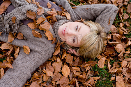 公司的符号摄影照片_躺在枯叶堆里的女人
