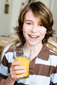 男孩端着一杯橙汁微笑