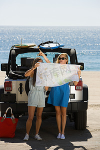 两个人抬头看摄影照片_乘车的年轻女性看地图