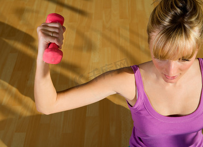 一名年轻女子在健身房举重