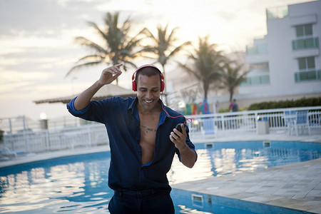 巴西里约热内卢一名中年男子在酒店泳池边随着智能手机音乐起舞