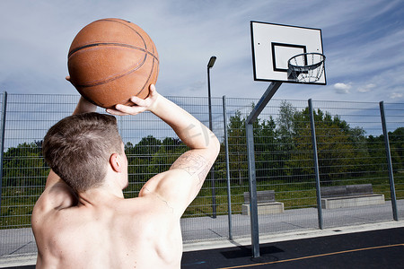篮球场摄影照片_一名男子在城市球场上打篮球