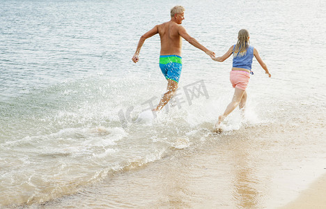 父女俩在海滩上奔跑牵手