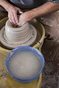 陶工手在陶轮上塑造陶罐的剪裁高角图