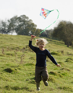 带着风筝奔跑的小男孩