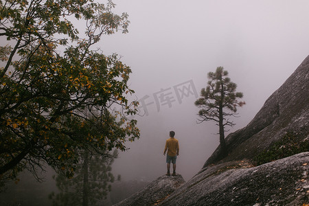 站在岩石上的年轻人俯瞰着美国加利福尼亚州沙弗湖附近的景色