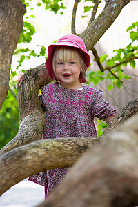 户外攀登摄影照片_女孩在森林里爬树