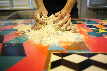 雪摄影照片_妇女用手在厨房桌子上做面团的特写