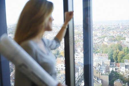 新年规划摄影照片_从办公室窗户凝视比利时布鲁塞尔城市景观的女建筑师