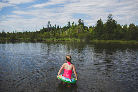 加拿大安大略省印第安河上戴橡皮圈的女孩的背影