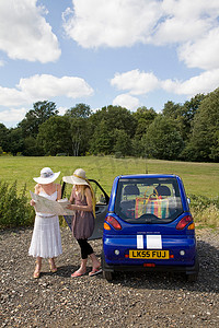 汽车科技感摄影照片_乘坐电动汽车拿着地图的年轻女性