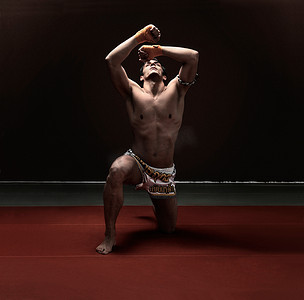 武术和拳击摄影照片_拳击手跪在垫子上