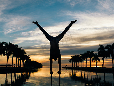 美国佛罗里达州迈阿密南海滩南角公园黄昏时分成年男子在杆子上保持平衡
