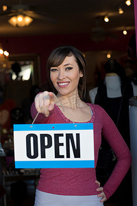 商商吊牌摄影照片_一名女子在商店里举着敞开的招牌