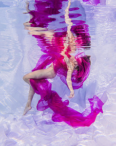 神秘摄影照片_身穿粉色布料的水下时装模特