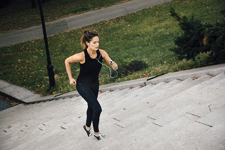 运动袜摄影照片_一名女子在公园里跑上台阶
