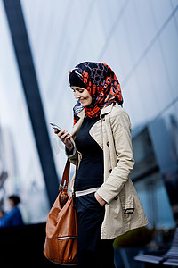 戴头巾的女子使用手机