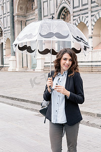 意大利托斯卡纳佛罗伦萨圣玛丽亚·诺维拉广场一位撑着伞微笑的年轻女子