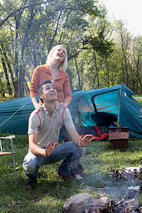 一对夫妇在露营地抬头看着浓烟