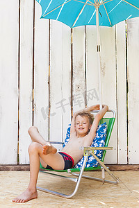 室内草坪椅上穿泳衣的男孩