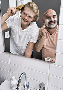 浴室里男性夫妇剃头和刷头的镜像