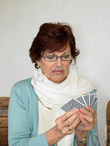 扑克牌扑克牌摄影照片_高级女人打牌拉脸