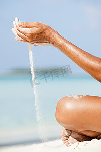 马尔代夫一位让沙子流过双手的妇女