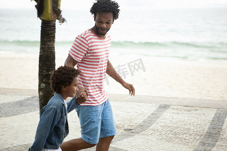 巴西里约热内卢伊帕内马海滩父子携手奔跑