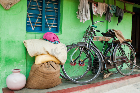 卡纳塔克邦迈索尔附近村舍外的自行车麻袋和破布