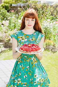 一名女子站在花园里的草莓馅饼上