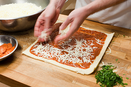 男厨师在商业厨房制作披萨