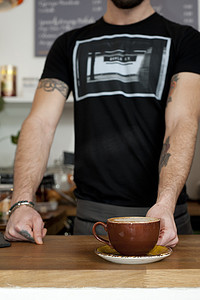 咖啡馆服务员端上一杯新鲜咖啡的剪影