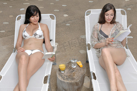 橙汁海报免费摄影照片_两个女人在读一本书