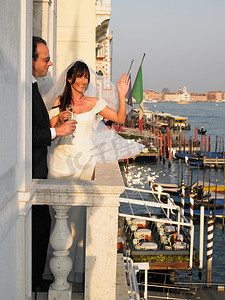 新娘和新郎在阳台上敬酒