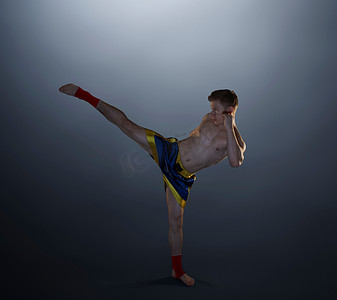 武术和拳击摄影照片_年轻男子踢腿拳击手的录音棚照片