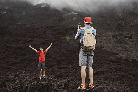 年轻男子在危地马拉安提瓜帕卡亚火山为朋友拍照