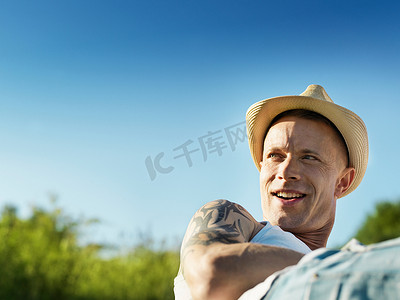 电视背景摄影照片_戴着太阳帽的微笑着的男人
