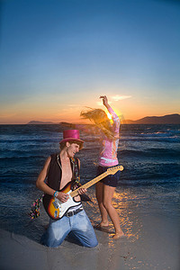 弹吉他在夕阳海边跳舞
