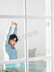 女性疲惫摄影照片_在电脑上工作的女性